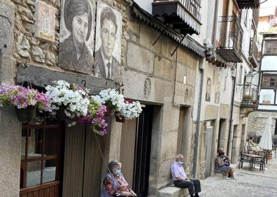 Imagen secundaria 1 - En la parte superior, cruces y cirios labrados en el portón de una vieja ermita en ruinas.; en las dos imágenes de debajo, diferentes zonas de Mogarraz, en Salamanca.