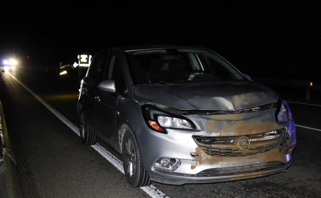 Un agente de la Guardia Civil regula el tráfico mientras el vehículo permanece parado en la carrtera tras el impacto con el jabalí. 