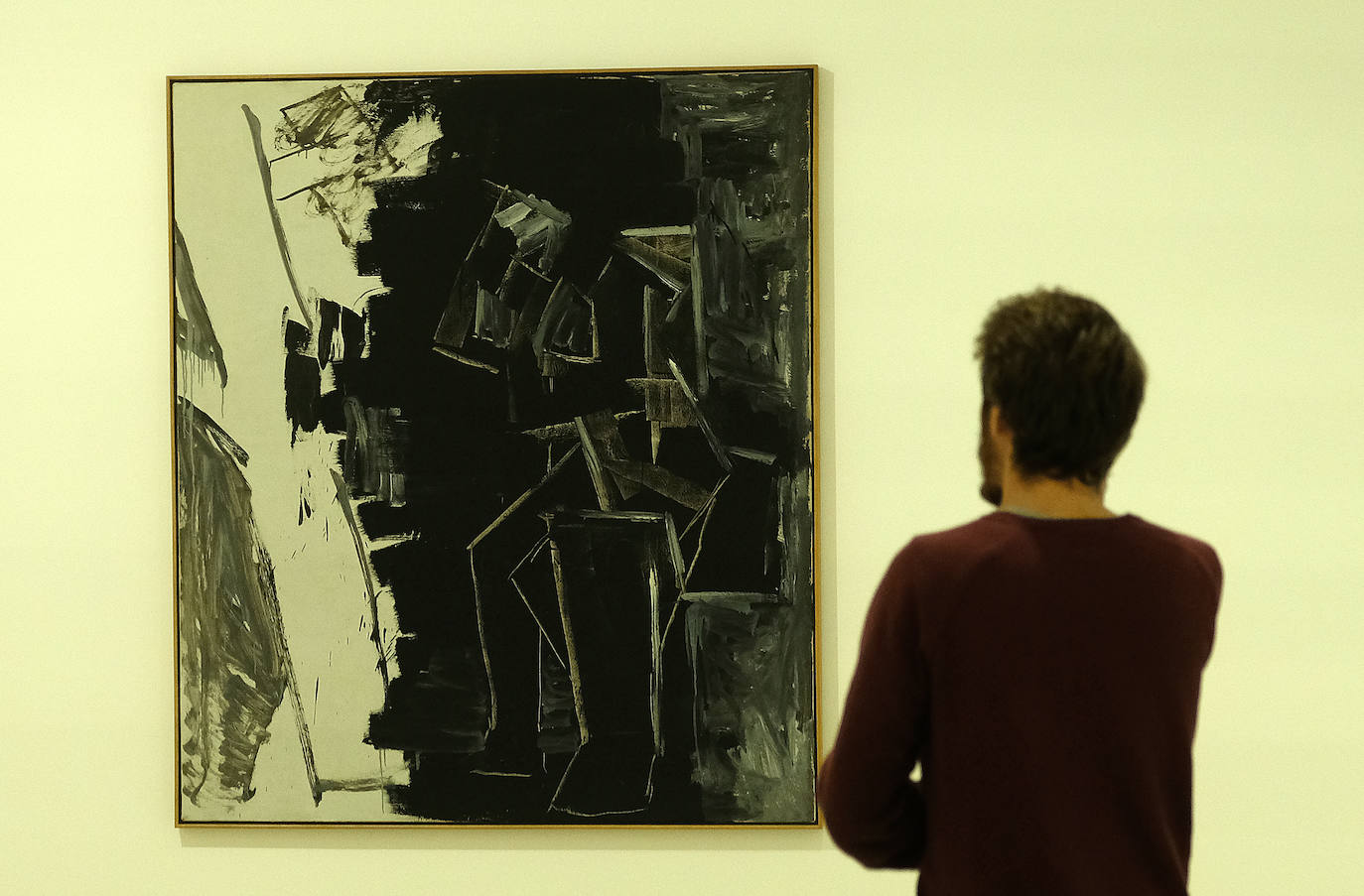 Una mujer observa uno de los cuadros de la exposición.