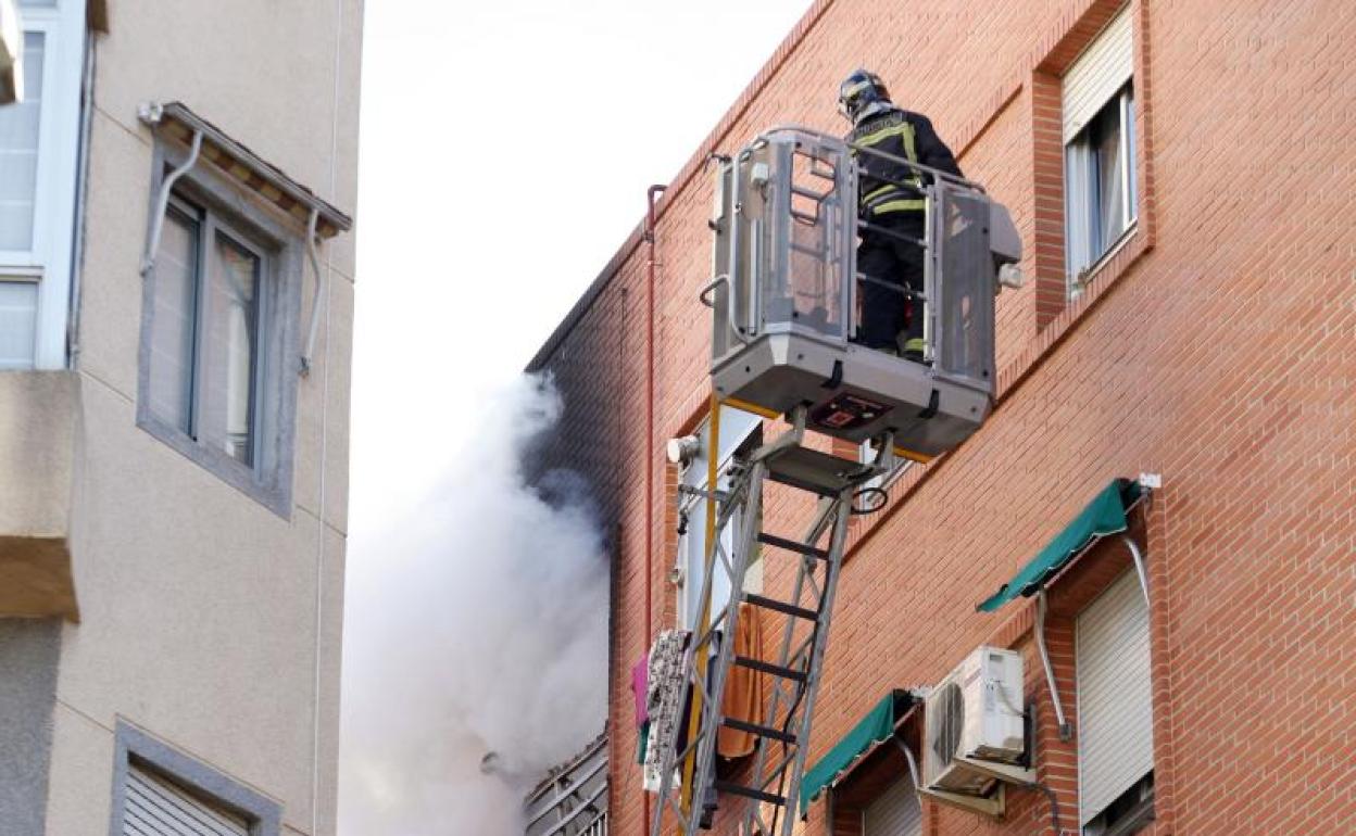 Los bomberos intervienen durante el incendio de una vivienda. 