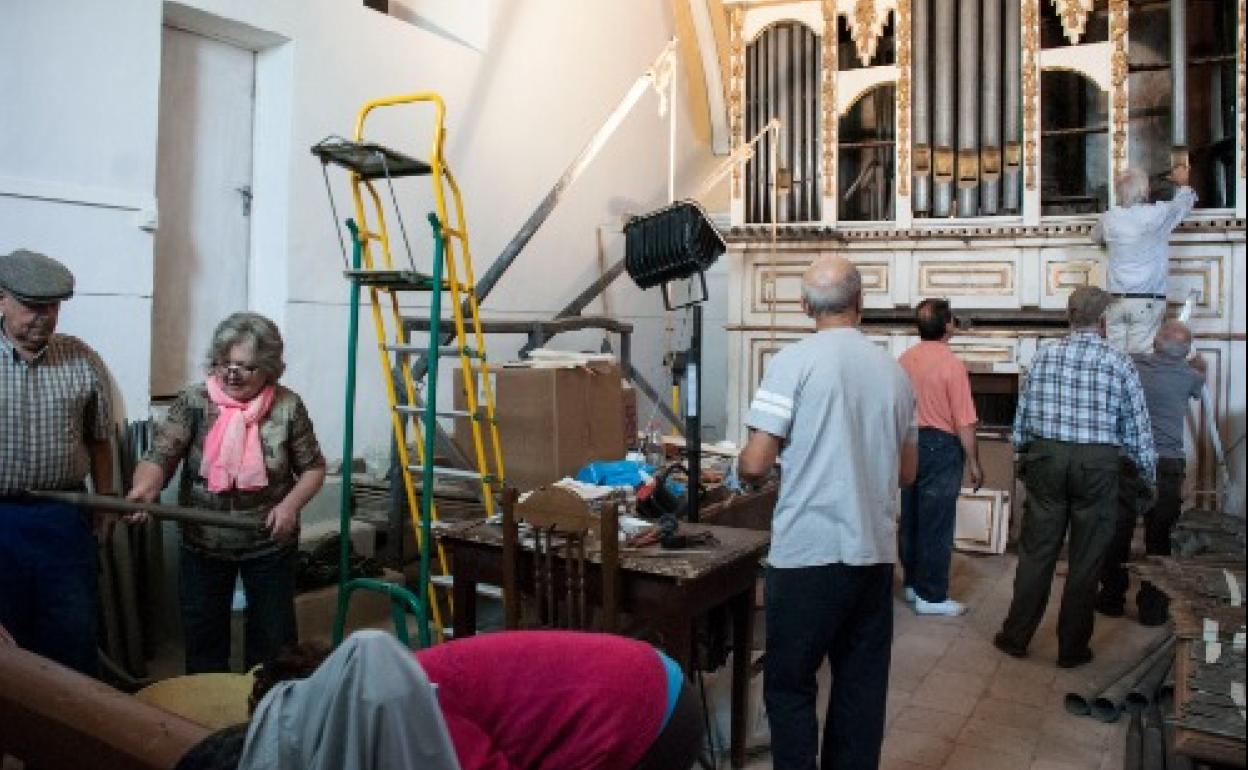 Vecinos trabajan en la restauración del órgano de la iglesia de San Zoilo de Escalona del Prado. 