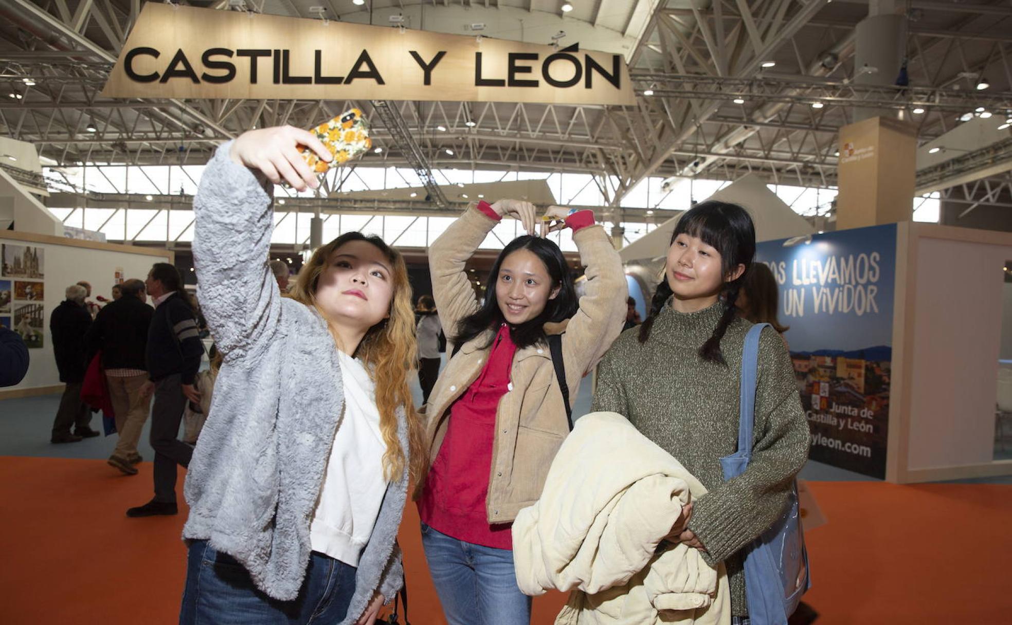 Tres jóvenes estudiantes japonesas se hacen un selfie en la Feria Internacional del Turismo de Interior de Valladolid. 