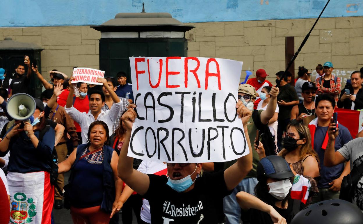 Opositores de Pedro Castillo muestran un cartel acusándole de corrupto.