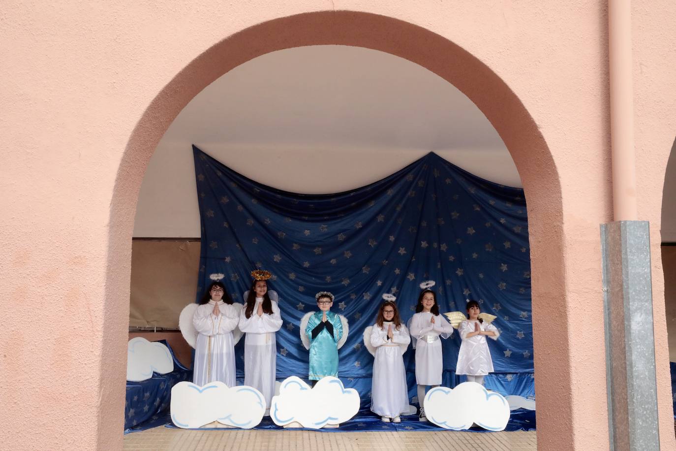 Ancianos observan a los alumnos interpretar el belén viviente.