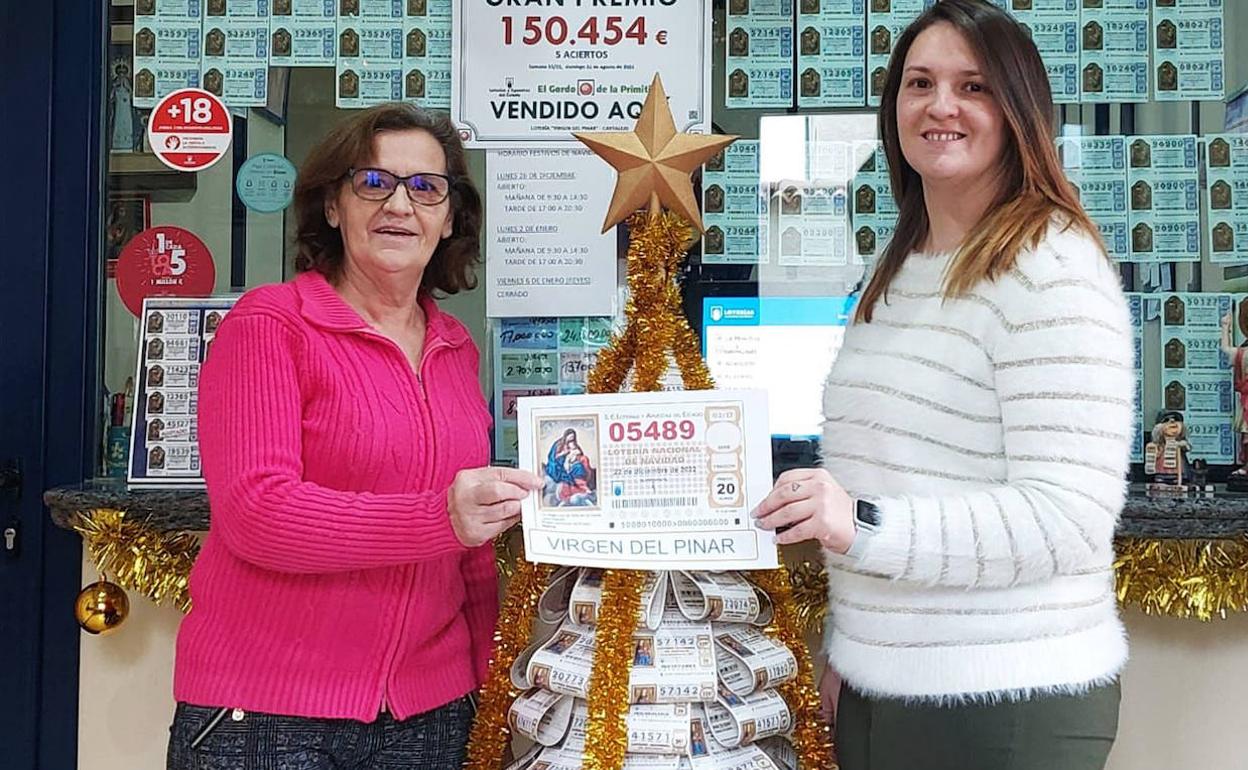 La lotera briquera María Ángeles San Inocente y su hija Ana Fresneda sostienen el número premiado por aproximación al Gordo de Navidad.