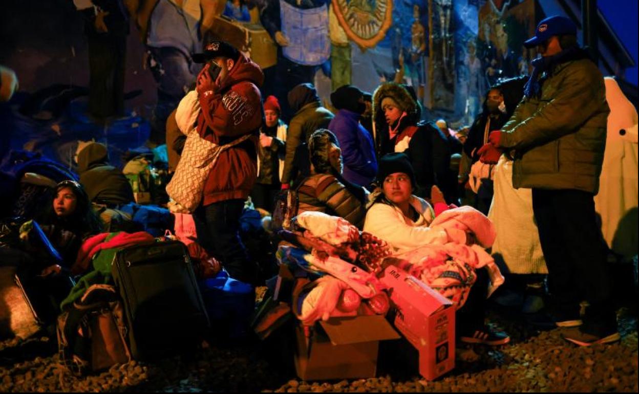 Migrantes descansan durante una noche de bajas temperaturas en el centro de El Paso, Texas. 