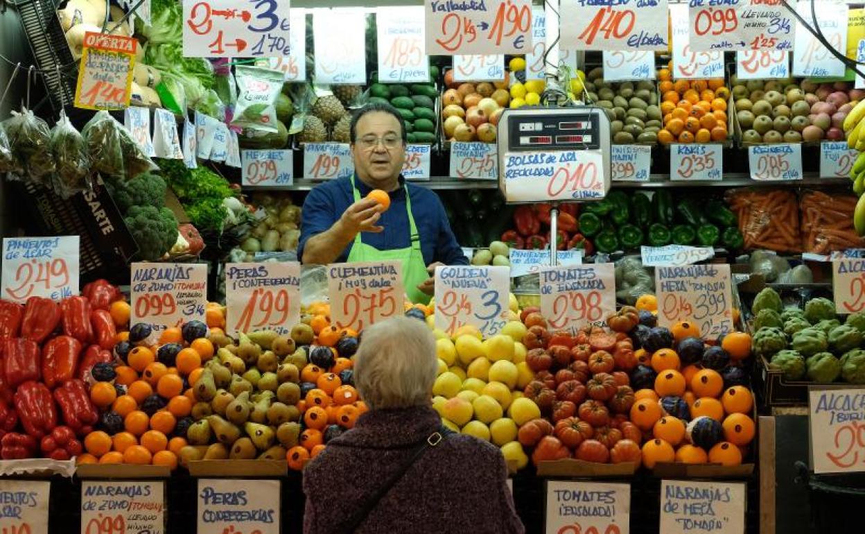 Una mujer ante un puesto de fruta en un mercado vallisoletano.