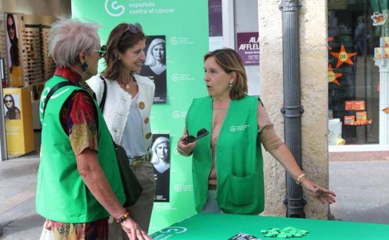 La presidenta de la AECC en Palencia, Rosa María Andrés (derecha), en una mesa informativa en la calle Mayor.