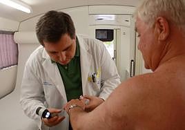 Un dermatólogo inspecciona la piel de su paciente.