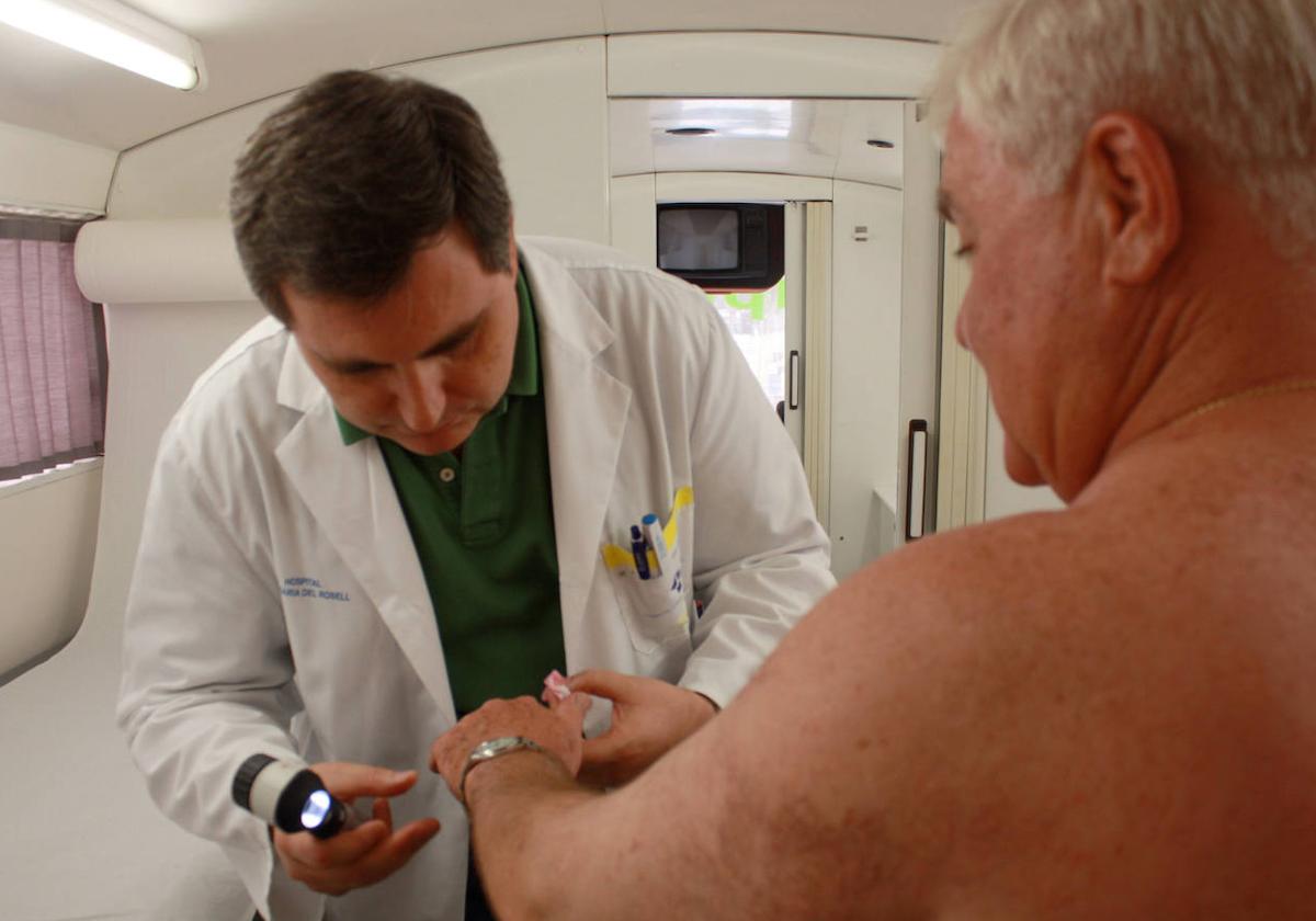 Un dermatólogo inspecciona la piel de su paciente.