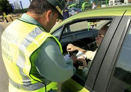 Un agente de la Guardia Civil de Tráfico revisa la documentación de un conductor.