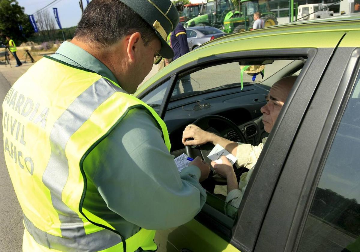 Un agente de la Guardia Civil de Tráfico revisa la documentación de un conductor.