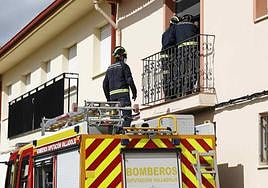Los bomberos accediendo a la vivienda por un balcón.