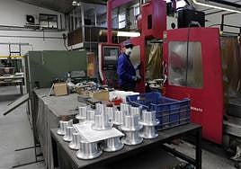 Un trabajador del sector industrial, el de mayor subida salarial, maneja una máquina.