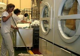 Varios trabajadores en una lavandería industrial.
