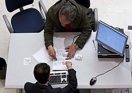 Un funcionario resuelve un trámite en una oficina de la Agencia Tributaria.