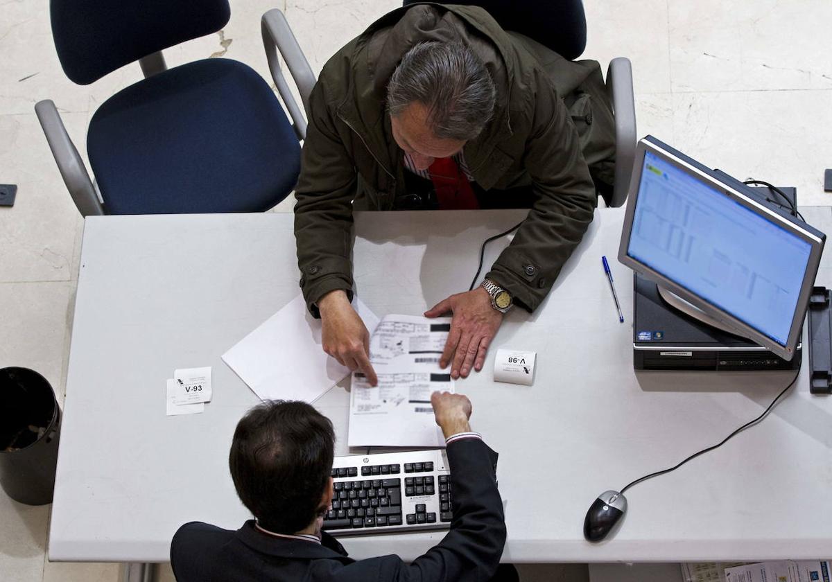 Un funcionario resuelve un trámite en una oficina de la Agencia Tributaria.