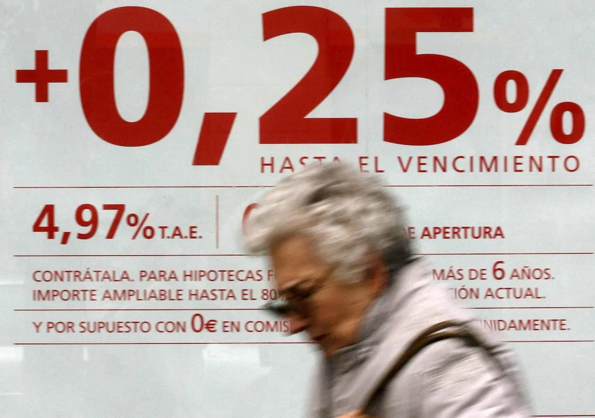 Una mujer pasa por delante de un cartel publicitario de una entidad bancaria en la que anuncia una oferta hipotecaria.