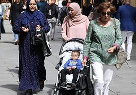 Dos mujeres musulmanas pasean un carrito de niño entre el resto de transeúntes por una calle de Segovia.