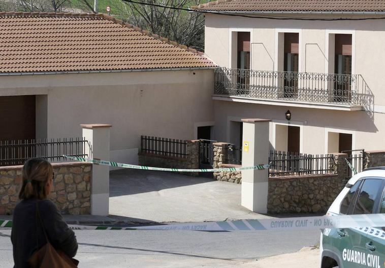 Una mujer observa la vivienda precintada de la mujer y el joven fallecidos en un pueblo de Segovia.