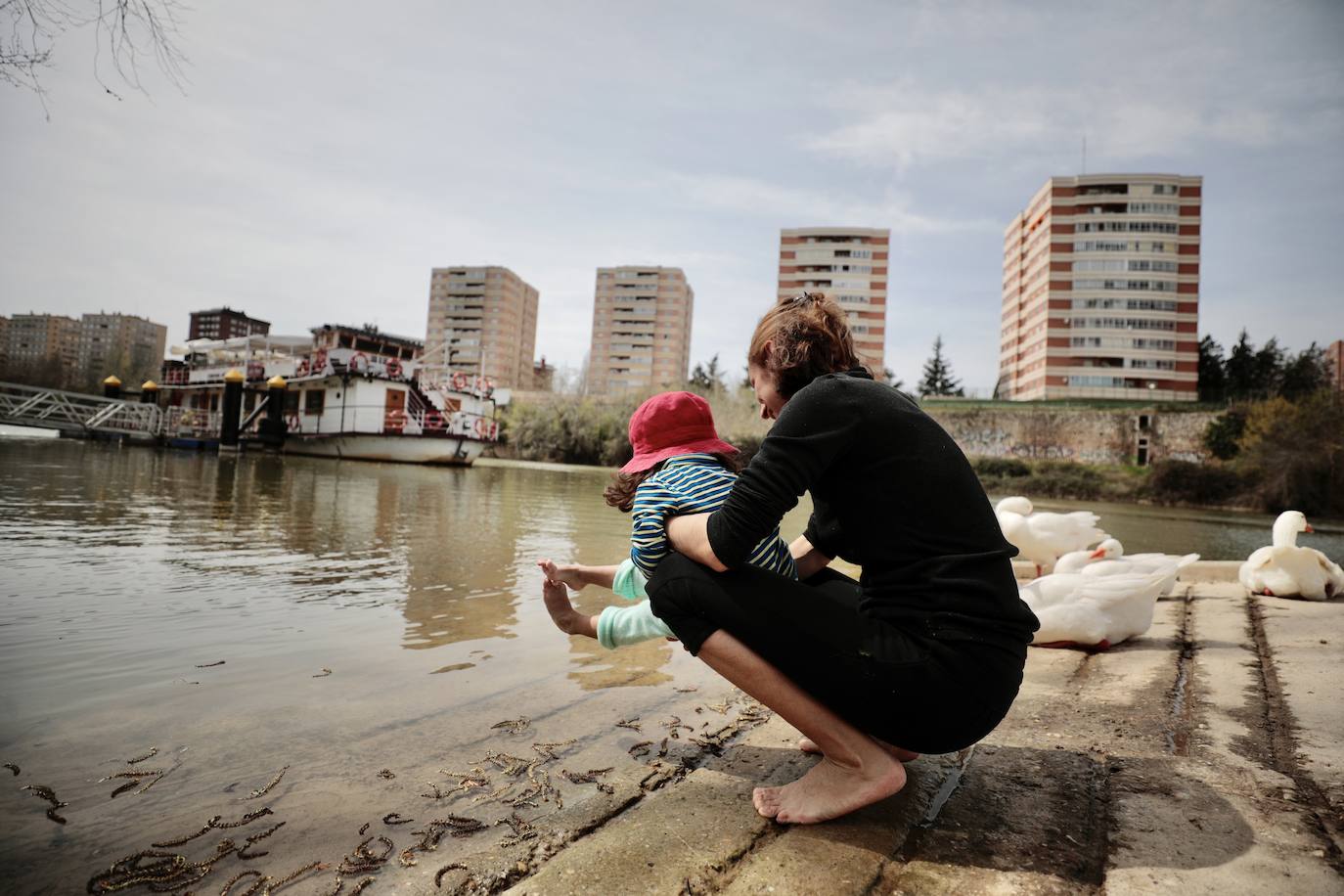 Una madre y su hija se refrescan en el Pisuerga.