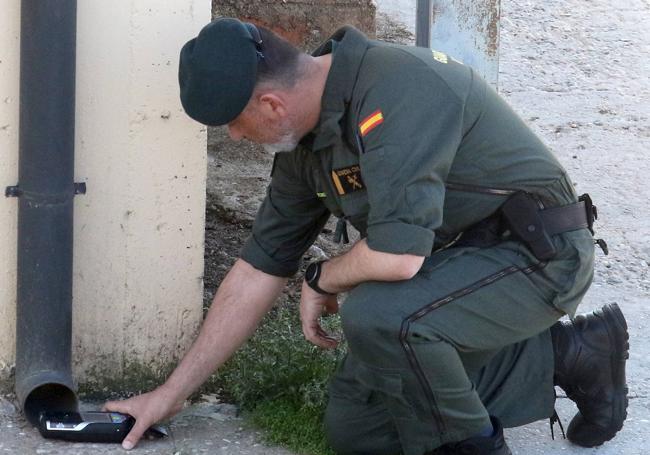 Un agente mide la toxicidad en la salida de un canalón en la vivienda afectada.