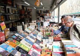 Varios clientes miran uno de los puestos de la Feria del Libro Antiguo y de Ocasión.