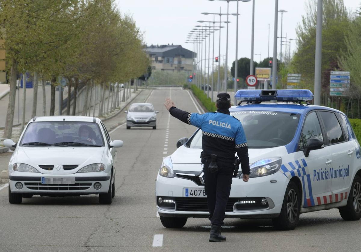 Un agente para un vehículo en un control policial.