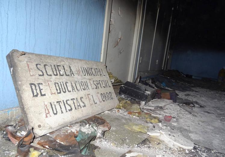 Imagen principal - Arriba, el antiguo letrero de piedra de la escuela municipal El Corro. Debajo, basuras, cascotes y colchones en la última habitación que estuvo habitada de la planta superior y estado de uno de los aseos.