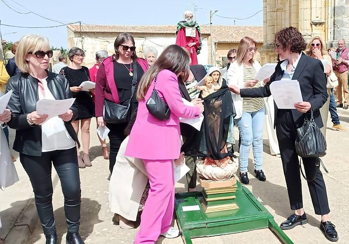 Retirada del velo que cubría la imagen de la Virgen. Al fondo, la figura de Judas.