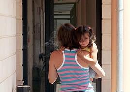 Una madre lleva a su hija en brazos a un centro de salud de la provincia.