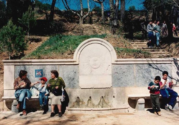 Imagen principal - Arriba, vecinos merendando junto a la Fuente El Sol en los años noventa. Debajo, a la izquierda, columpios en 1973. A la derecha, resultado de los trabajos de regeneración forestal y paisajista de 1997.