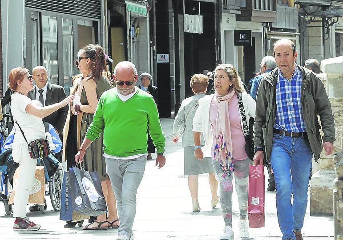 La Calle Mayor repleta de gente con bolsas, este jueves.