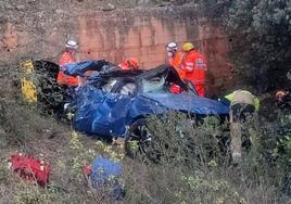 Personal de emergencias junto al vehículo accidentado.