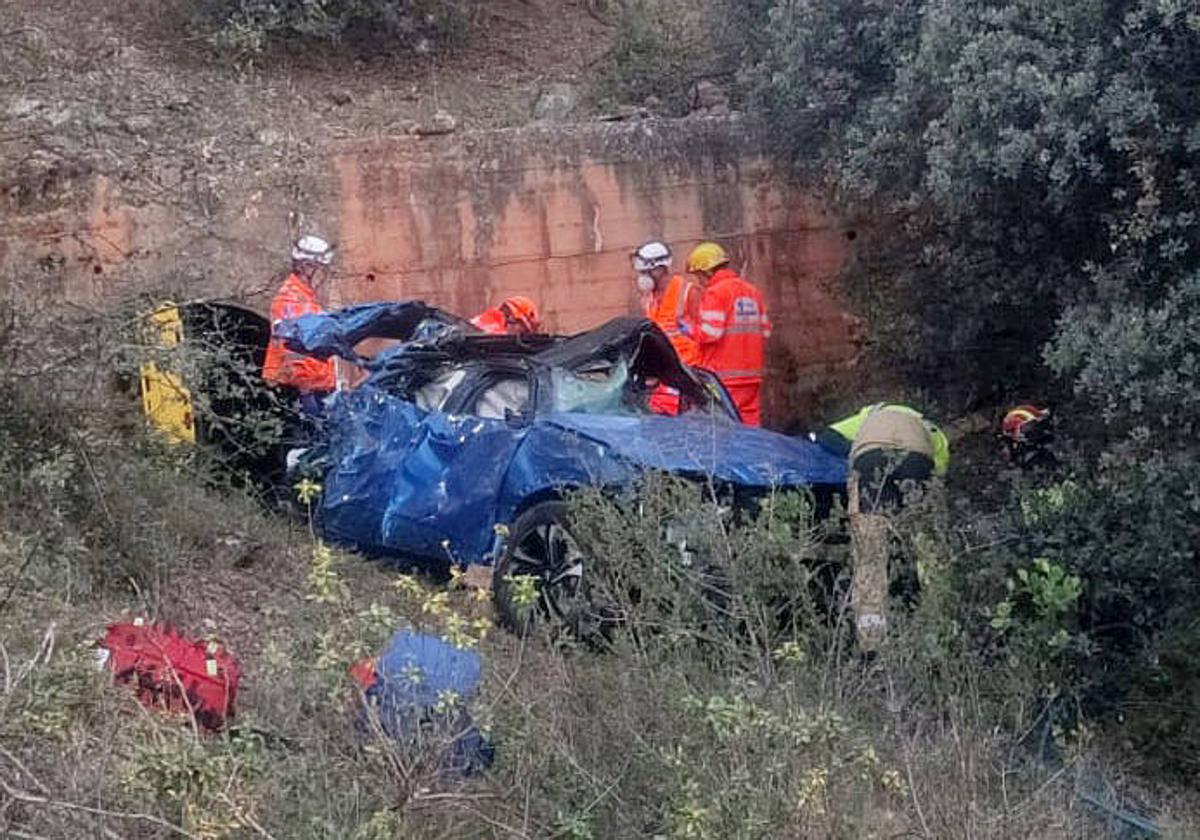 Personal de emergencias junto al vehículo accidentado.