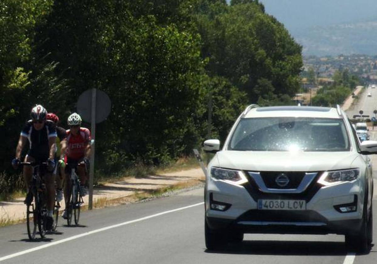 Ciclistas en grupo y coches en una carreta de Segovia