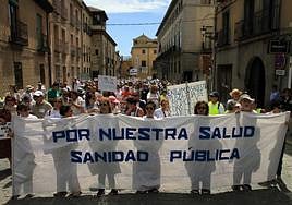 Varias personas portan una pancarta en la cabecera de la manifestación, a su paso por la calle San Agustín.