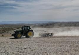 Un tractor ara la tierra en un campo de Aragón.