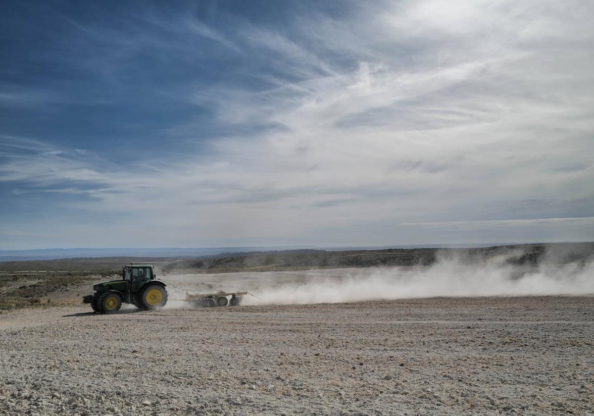 Un tractor ara la tierra en un campo de Aragón.