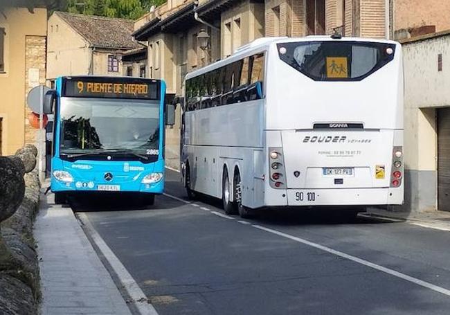 Un autobús se sube a la acera para dejar pasar a otro vehículo pesado en el barrio de San Marcos.