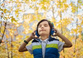 Foto de un niño escuchando música en sus auriculares.