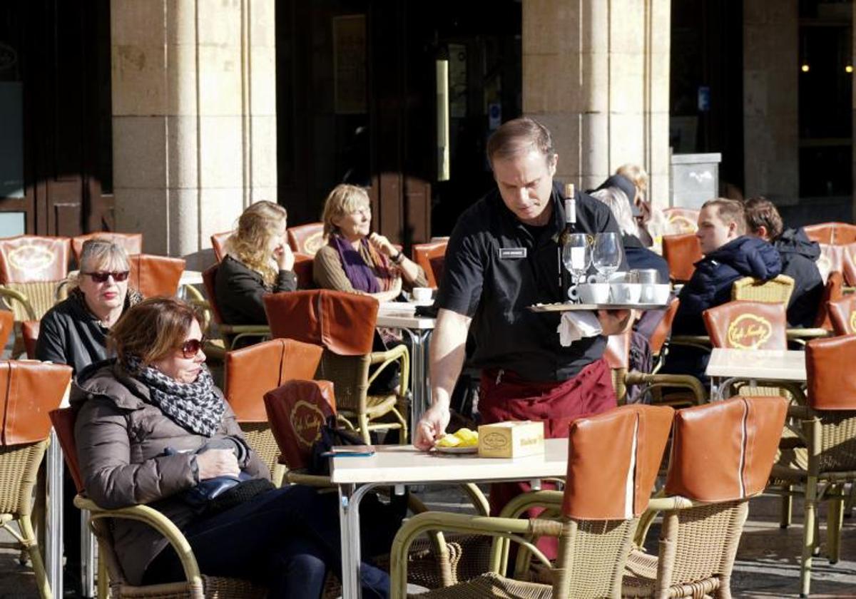 Un camarero sirve consumiciones en una terraza de la Plaza Mayor de Salamanca.