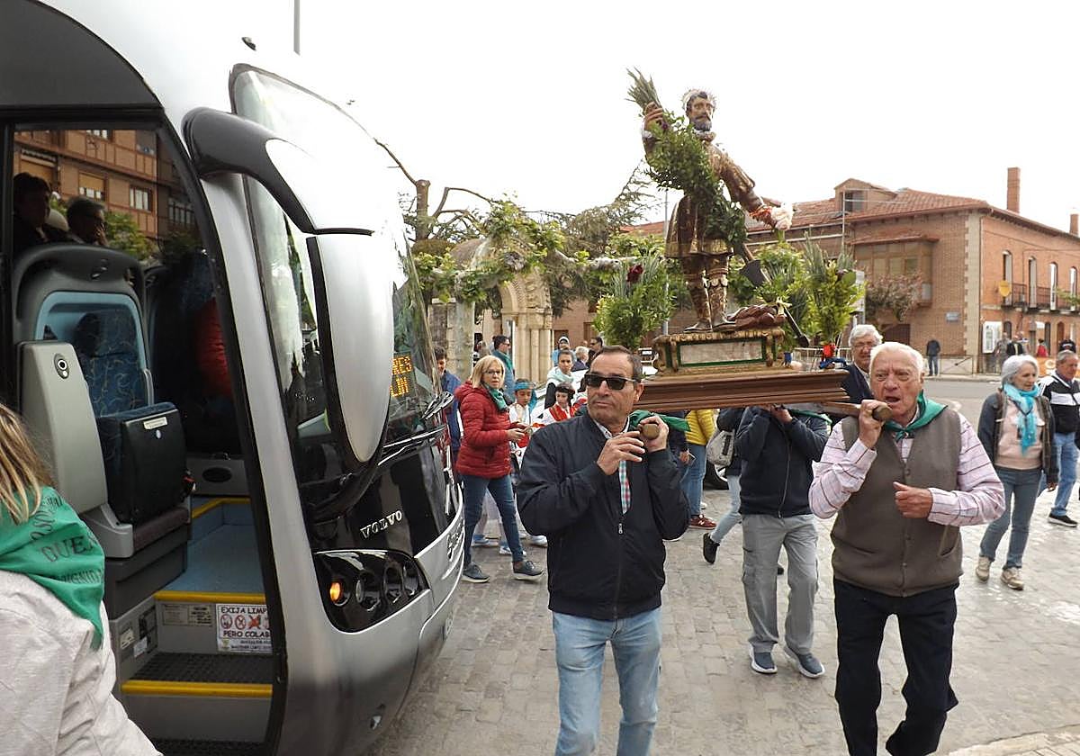 Los vecinos portan al santo en la plaza de Dueñas para subirlo al autobús y desplazarse hasta La Trapa.