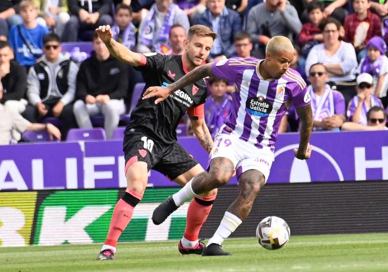 Kenedy conduce el balón perseguido por Rakitic.