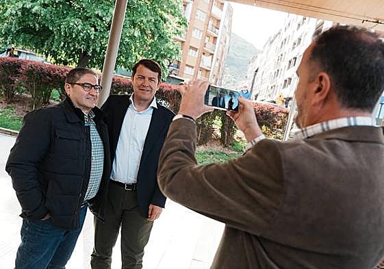 Carlos Iturgáiz, presidnete del PP vasco, fotografía al presidente del PP de Castilla y León, Alfonso Fernández Mañueco, junto a un simpatizante en Baracaldo.