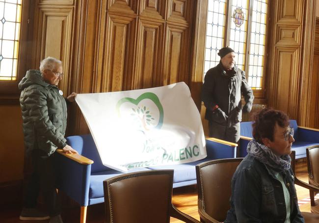 Un grupo de opositores coloca una pancarta en el pleno, que tuvo que ser retirada tras una advertencia del alcalde.