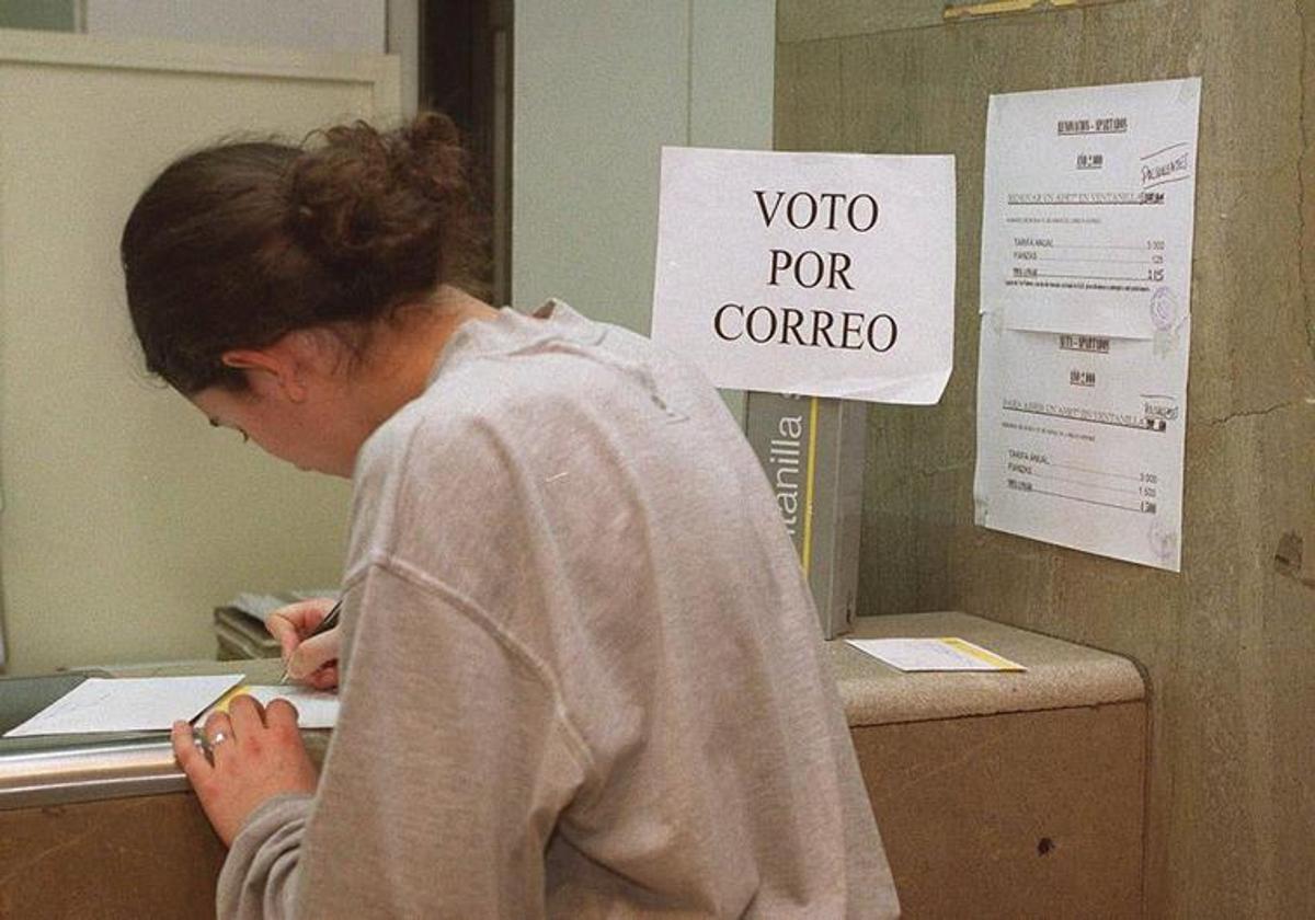 Una joven solicita el voto por correo en una oficina.