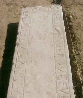 Imagen secundaria 2 - Arriba, vista actual de la plaza de San Miguel. Debajo, a la izquierda, reflejo en el pavimento de la localización de las lápidas. A la derecha, una de las lápidas funerarias halladas en las excavaciones.