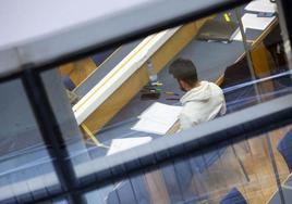 Un joven estudia en la biblioteca de la Facultad de Filosofía y Letras.