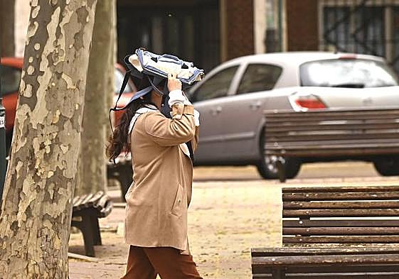 Una mujer se protege de la lluvia el jueves en Valladlid.